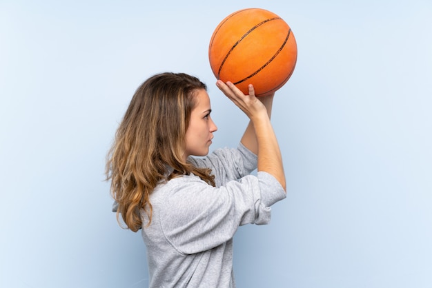 Giovane donna bionda con palla di basket