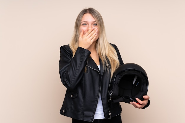 Giovane donna bionda con un casco da motociclista con espressione facciale a sorpresa