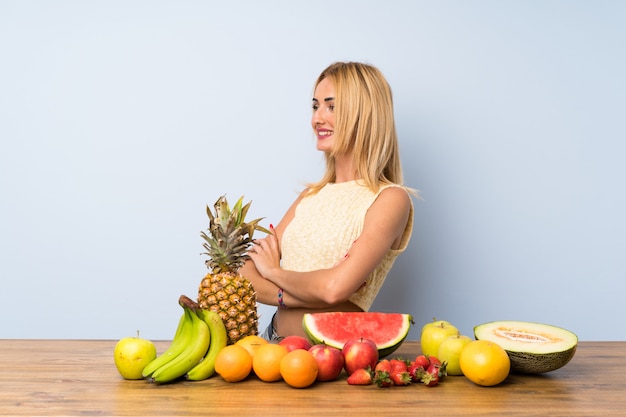 Giovane donna bionda con un sacco di frutti guardando al lato