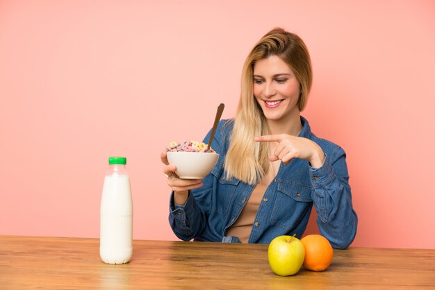 Giovane donna bionda con una ciotola di cereali