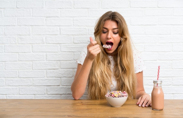 Giovane donna bionda con una ciotola di cereali