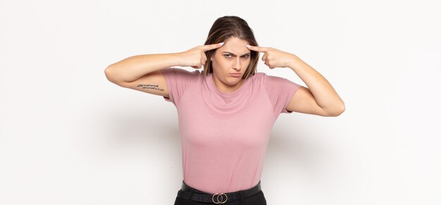 Giovane donna bionda con uno sguardo serio e concentrato, brainstorming e pensando a un problema impegnativo