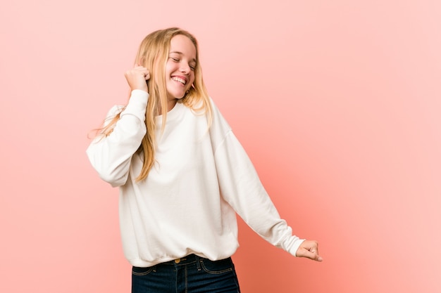 Giovane donna bionda dell'adolescente che balla e che si diverte.