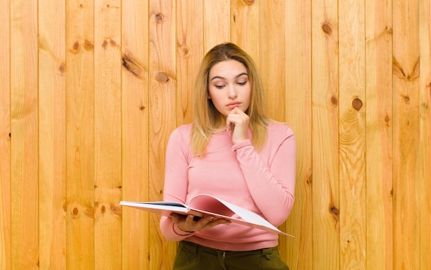 Giovane donna bionda graziosa con i libri