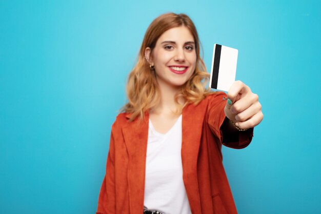 Giovane donna bionda graziosa con la carta di credito