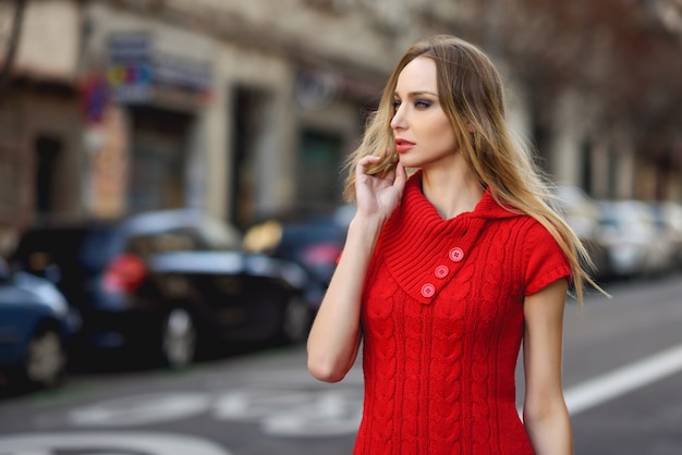 Giovane donna bionda guardando qualcosa in strada