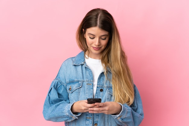 Giovane donna bionda isolata utilizzando il telefono cellulare