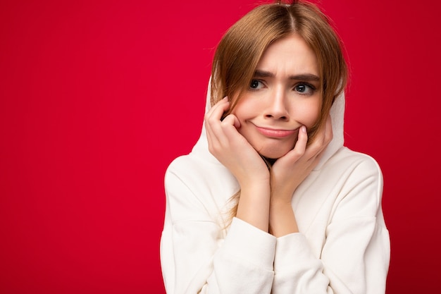 Giovane donna bionda scura bella stanca insoddisfatta con emozioni sincere isolato su priorità bassa