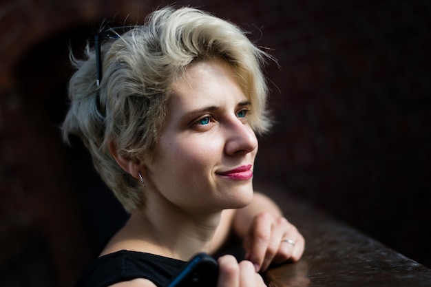 Giovane donna bionda sorridente felice che cammina in città