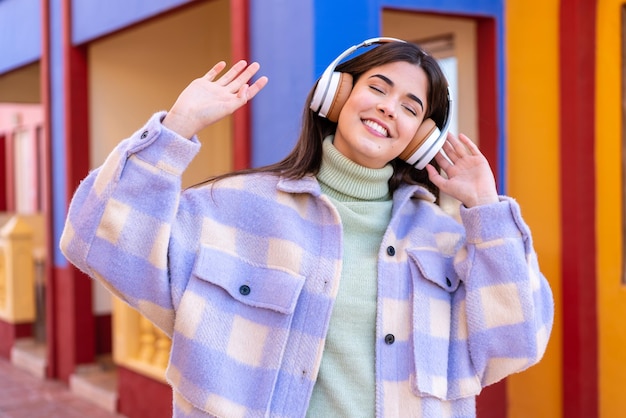 Giovane donna brasiliana all'aperto ascoltando musica e ballando