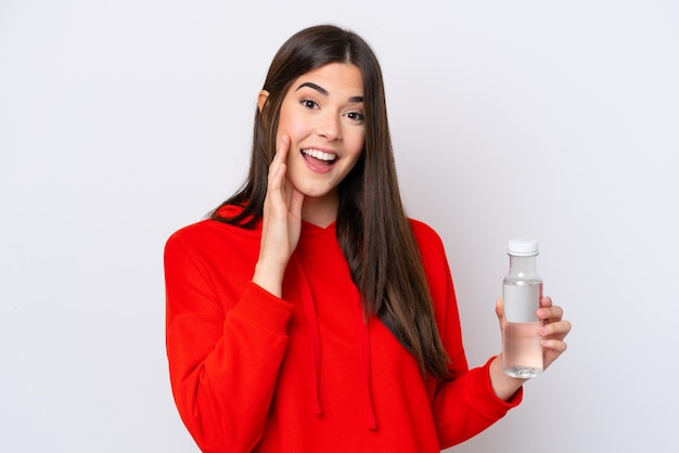 Giovane donna brasiliana con una bottiglia d'acqua isolata su sfondo bianco che grida con la bocca spalancata