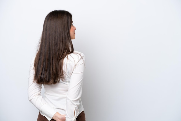 Giovane donna brasiliana isolata su sfondo bianco nella posizione posteriore e guardando indietro