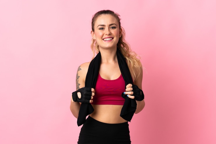 Foto giovane donna brasiliana isolata sul colore rosa con il tovagliolo di sport