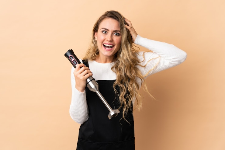 Foto giovane donna brasiliana utilizzando frullatore a immersione isolato