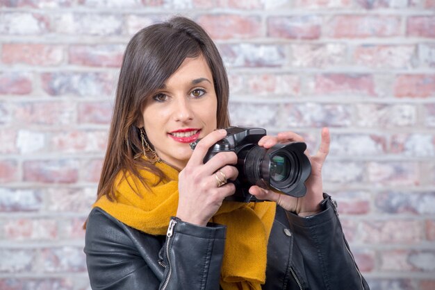 Giovane donna bruna con una macchina fotografica