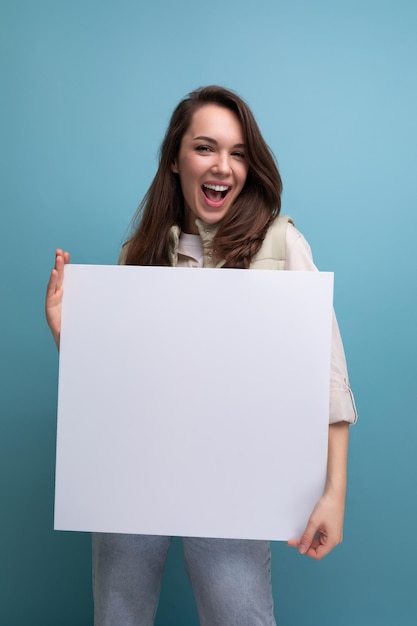 giovane donna bruna felice che tiene una tavola di carta con un modello