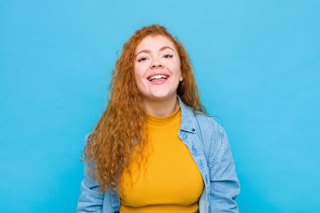 Giovane donna capa rossa con un sorriso grande, amichevole, spensierato