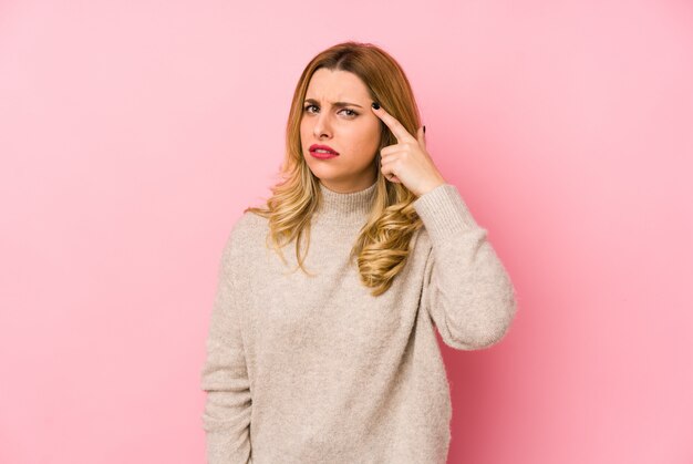 Giovane donna carina bionda che indossa un maglione isolato mostrando un gesto di delusione con l'indice.