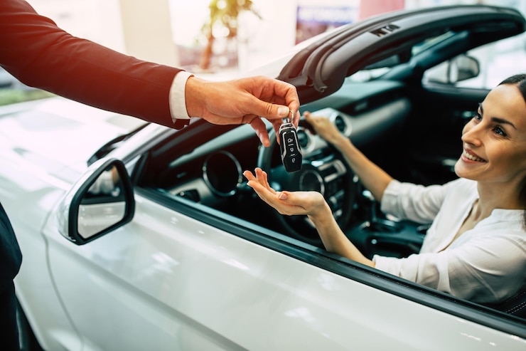 Foto giovane donna carina che compra una nuova auto per lavoro e viaggi in concessionaria ragazza cliente con venditore