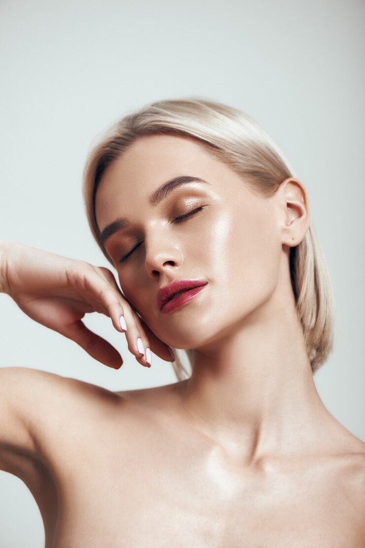 Giovane donna carina di bellezza sensuale con capelli biondi e pelle perfetta e lucida che tiene gli occhi chiusi