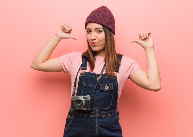 Giovane donna carina fotografo che punta le dita, esempio da seguire