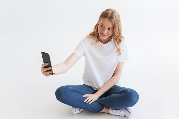 giovane donna carina rossa fare selfie dal telefono cellulare.