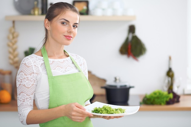 Giovane donna casalinga che cucina in cucina Concetto di pasto fresco e sano a casa