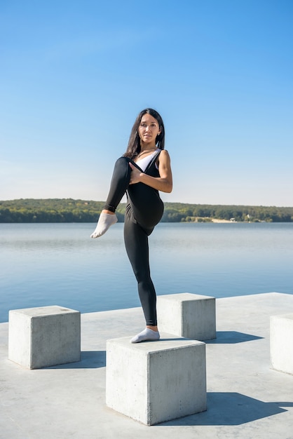 Giovane donna castana a praticare yoga la mattina presto prima dell'orario di lavoro. Concetto di benessere e stile di vita sano