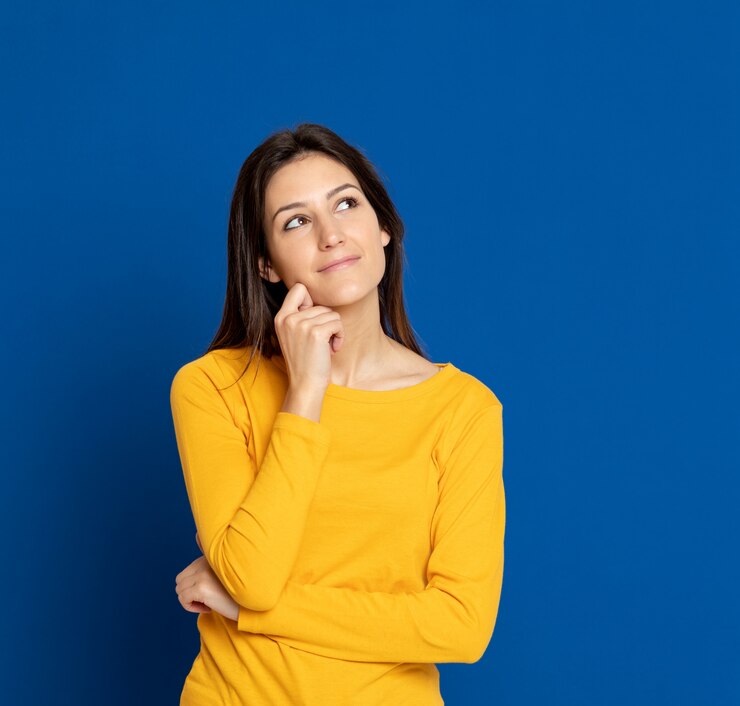 Foto giovane donna castana che gesturing sopra la parete blu