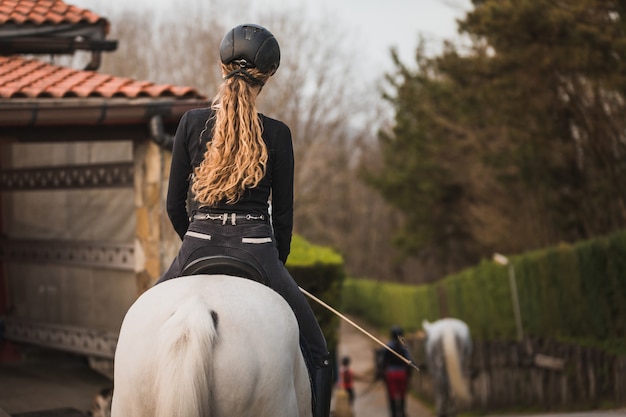 Giovane donna caucasica a cavallo in un centro ippico