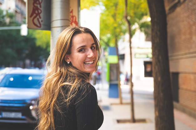 Giovane donna caucasica che cammina per le strade di Madrid, Spagna.