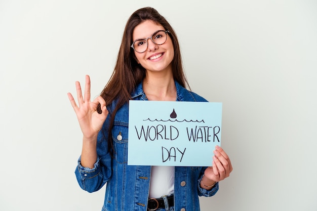 Giovane donna caucasica che celebra la giornata mondiale dell'acqua isolata sulle unghie mordaci rosa, nervosa e molto ansiosa.