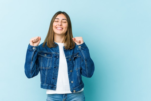 Giovane donna caucasica che celebra una vittoria, passione ed entusiasmo, felice espressione.