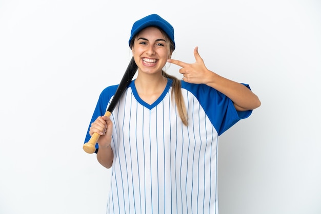 Giovane donna caucasica che gioca a baseball isolata su fondo bianco che dà un gesto di pollice in alto