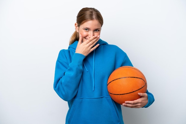 Giovane donna caucasica che gioca a basket isolato su sfondo bianco felice e sorridente che copre la bocca con la mano