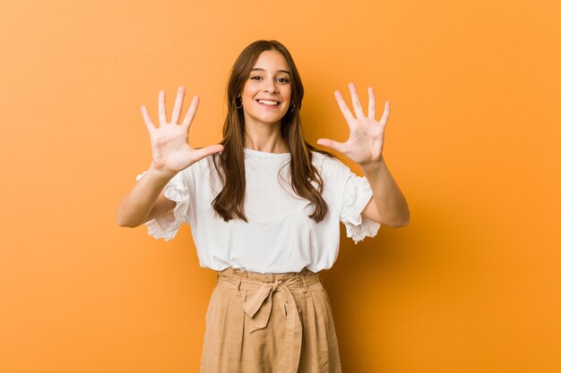 Giovane donna caucasica che mostra il numero dieci con le mani.