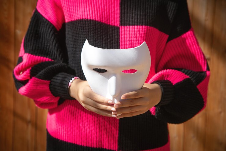 Giovane donna caucasica che mostra una maschera bianca