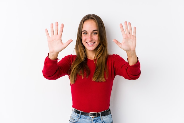 Giovane donna caucasica che posa mostrando numero dieci con le mani.