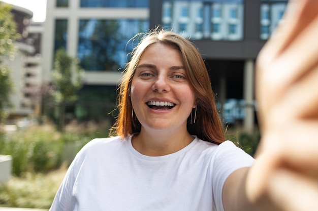 Giovane donna caucasica che prende la foto dell'autoritratto del selfie sullo smartphone durante l'alta qua di festival di musica