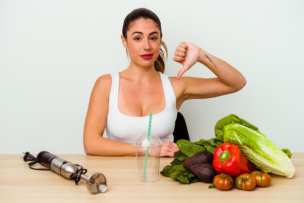 Giovane donna caucasica che prepara un frullato sano con le verdure