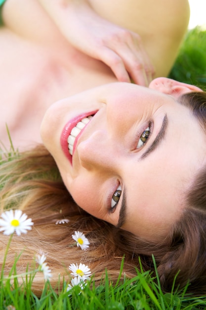 Giovane donna caucasica che sorride all&#39;aperto con i fiori