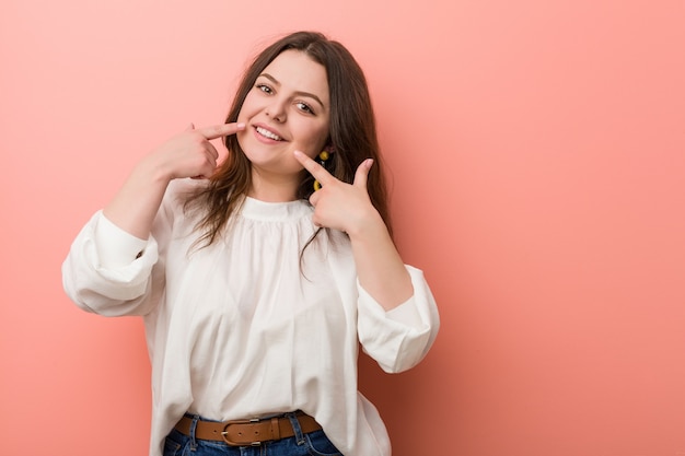 Giovane donna caucasica che sta contro il fondo rosa