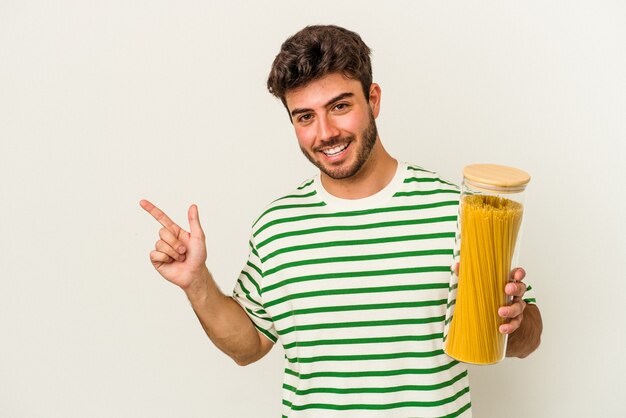 Giovane donna caucasica che tiene il barattolo di pasta isolato su sfondo bianco sorridente e rivolto da parte, mostrando qualcosa in uno spazio vuoto.