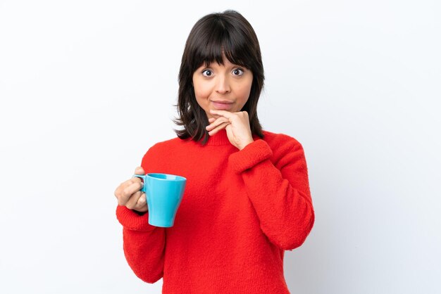 Giovane donna caucasica che tiene tazza di caffè isolata sul pensiero bianco del fondo