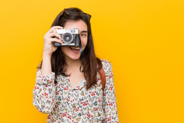 Giovane donna caucasica che tiene una macchina fotografica d'epoca