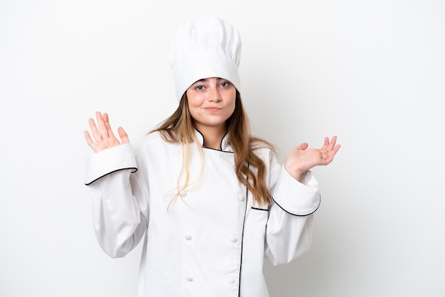 Giovane donna caucasica chef isolata su sfondo bianco che ha dubbi mentre alza le mani
