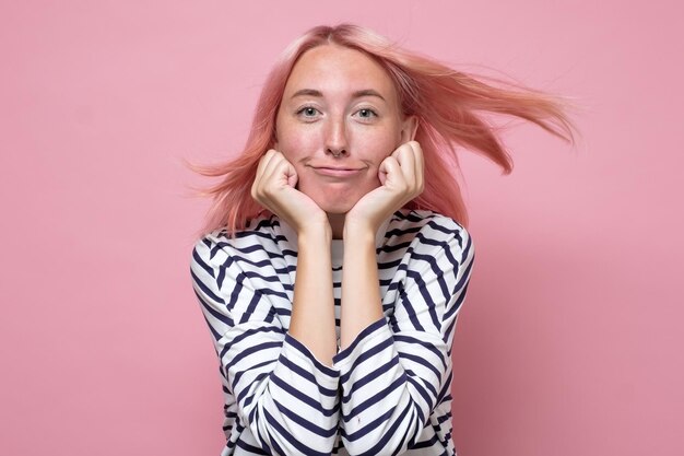 Giovane donna caucasica con i capelli tinti che looling alla macchina fotografica e sorridente