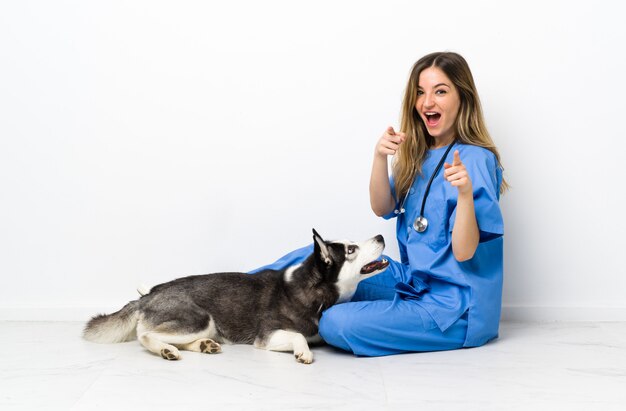 Giovane donna caucasica con il cane sopra la parete isolata