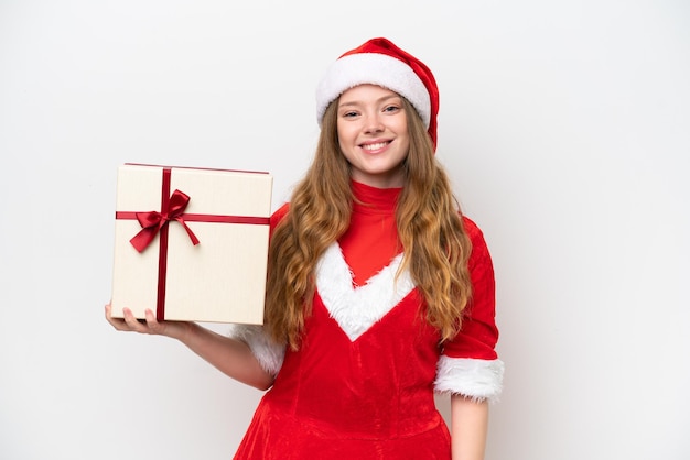 Giovane donna caucasica con il regalo della tenuta del vestito di Natale isolato su priorità bassa bianca che sorride molto