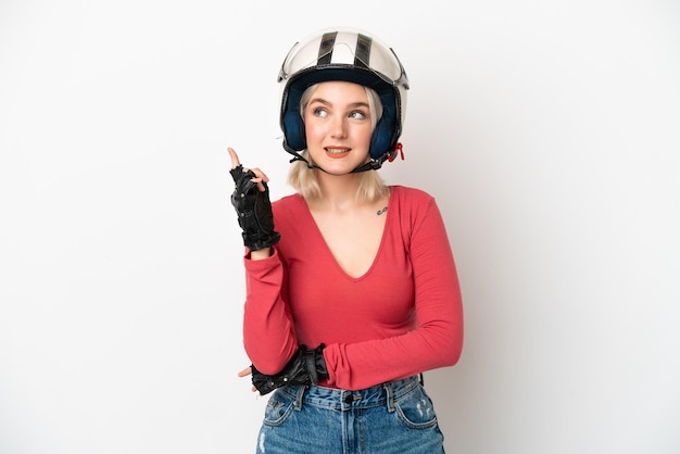 Giovane donna caucasica con un casco da motociclista isolato su sfondo bianco che indica una grande idea